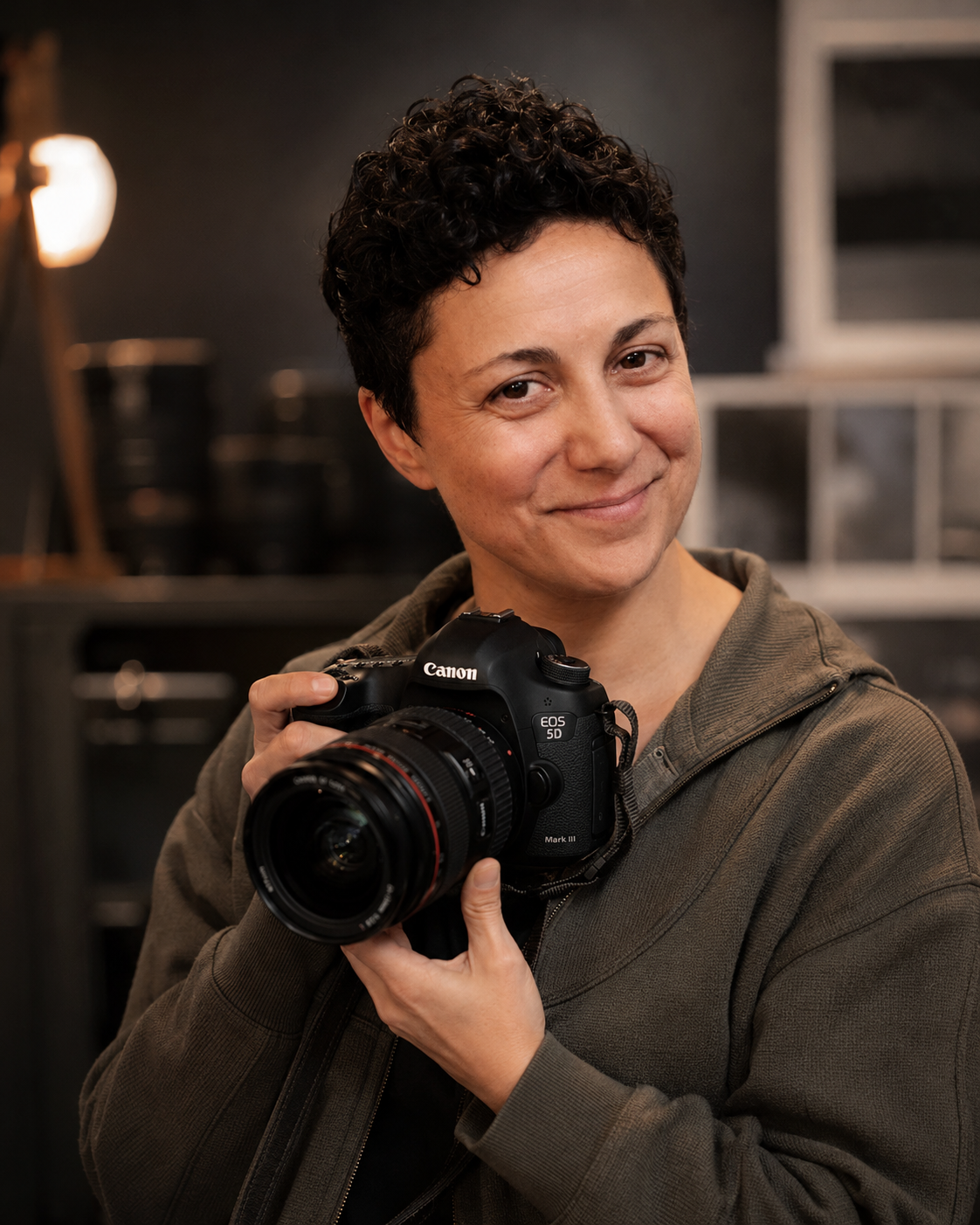 Cara H., photographer and videographer at CS & Co., holding a camera in the studio